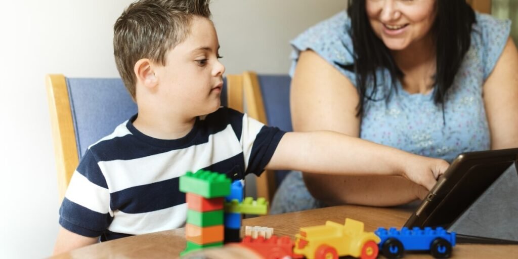 Caregiver and child with Down's Syndrome playing with blocks