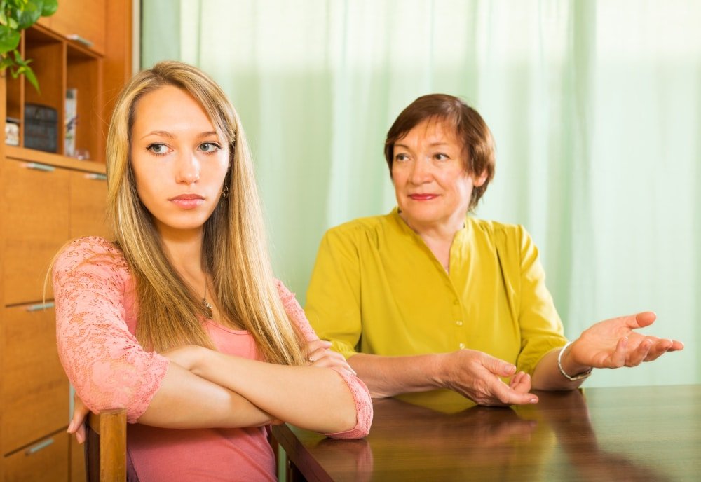 young woman turns her back on her mother