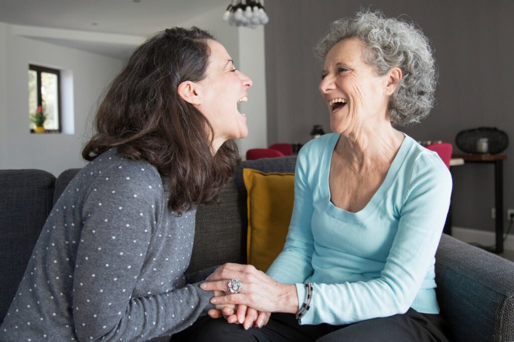 Daughter laughs with elderly mother.