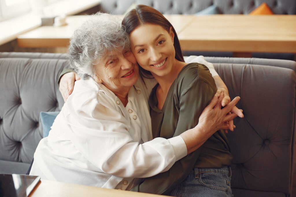 Granddaughter and grandmother embrace.