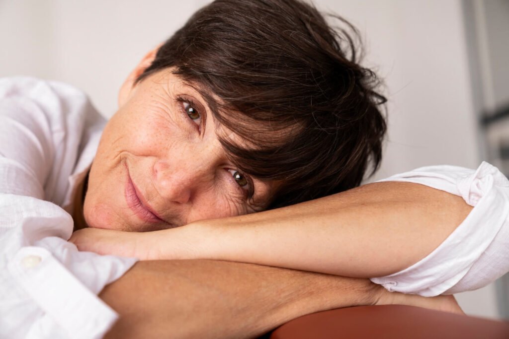 Relieved middle-aged caregiver smiles