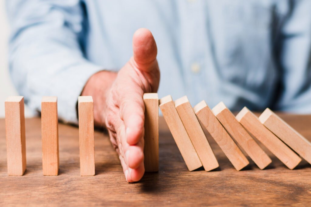 Hand prevents dominoes from falling