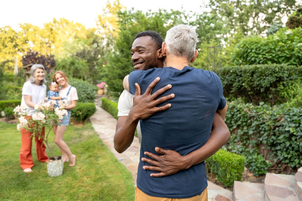 Two men give each other a supportive hug.