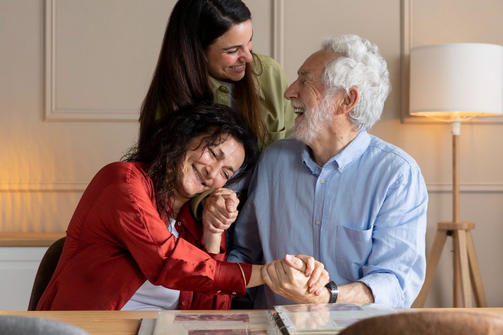 Daughters interact with elderly grandfather.