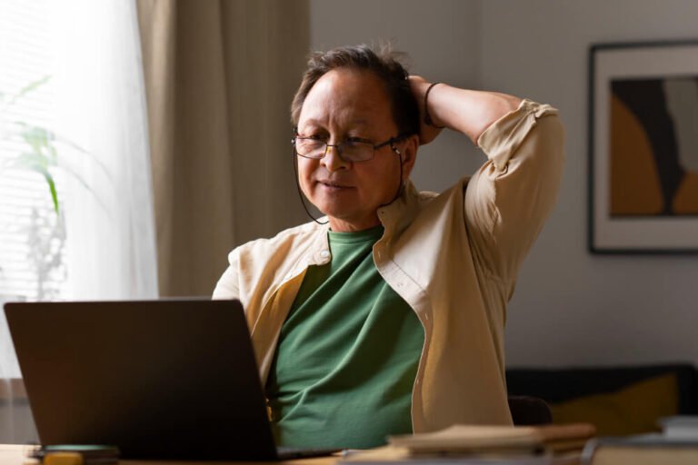 Senior man sitting at laptop with worried look on his face