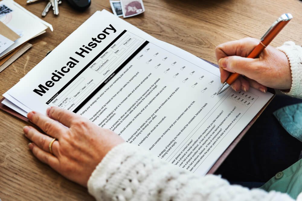 Close-up of hands filling out medical history form