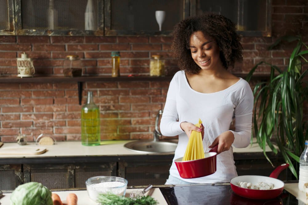 Female caregiver preparing spaghetti
