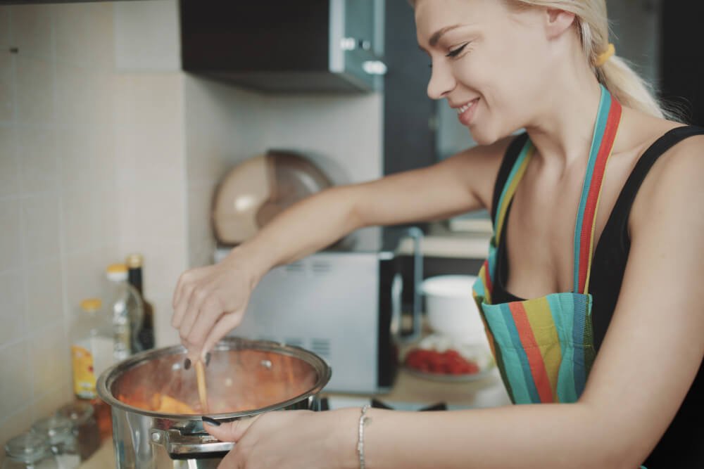 Woman cooking pot of soup