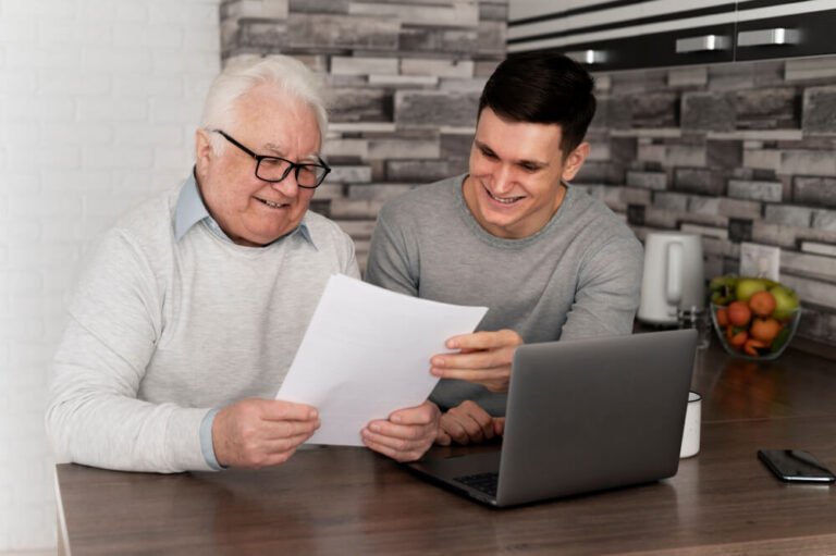 Young man helps his grandfather pay bills online.