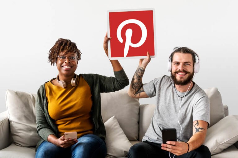 seated couple holds up pinterest logo