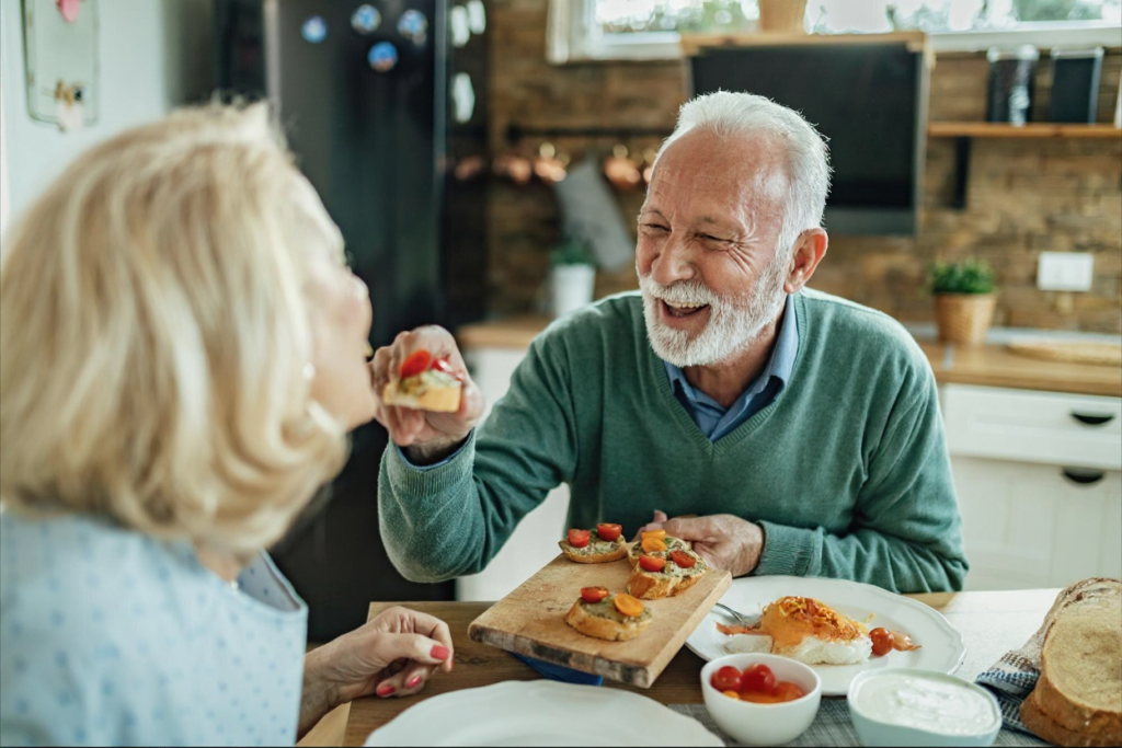 senior man feeds his wife small portions of food
