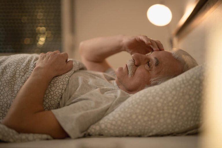 senior man restless in bed