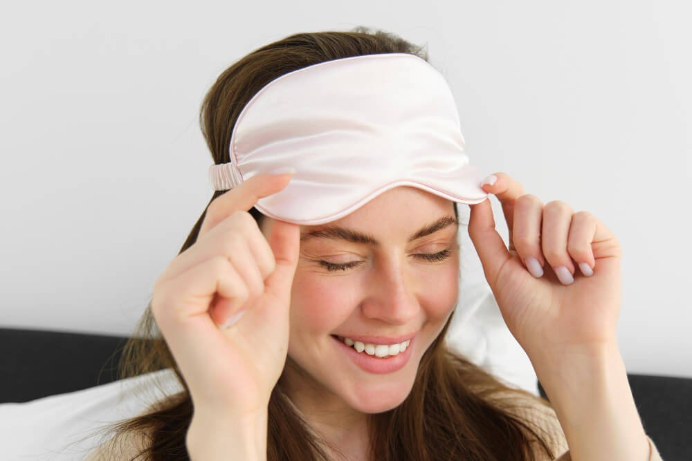 smiling young woman with silk sleep mask
