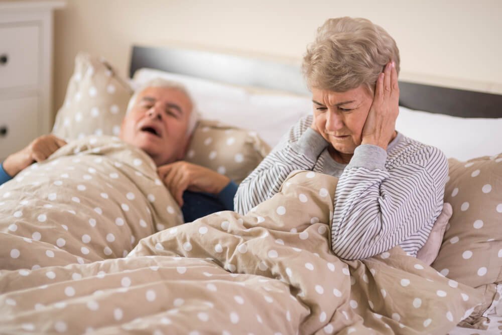snoring senior man with sleep apnes keeps spouse awake