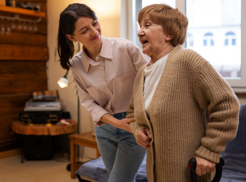 female caregiver assists elderly woman with cane