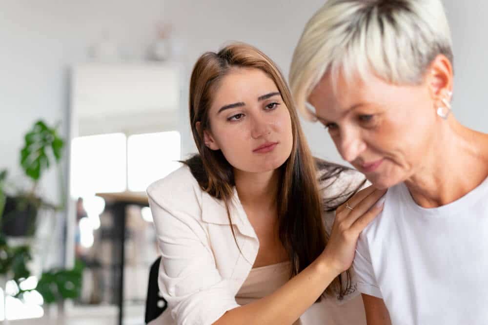 young woman comforts middle-aged woman