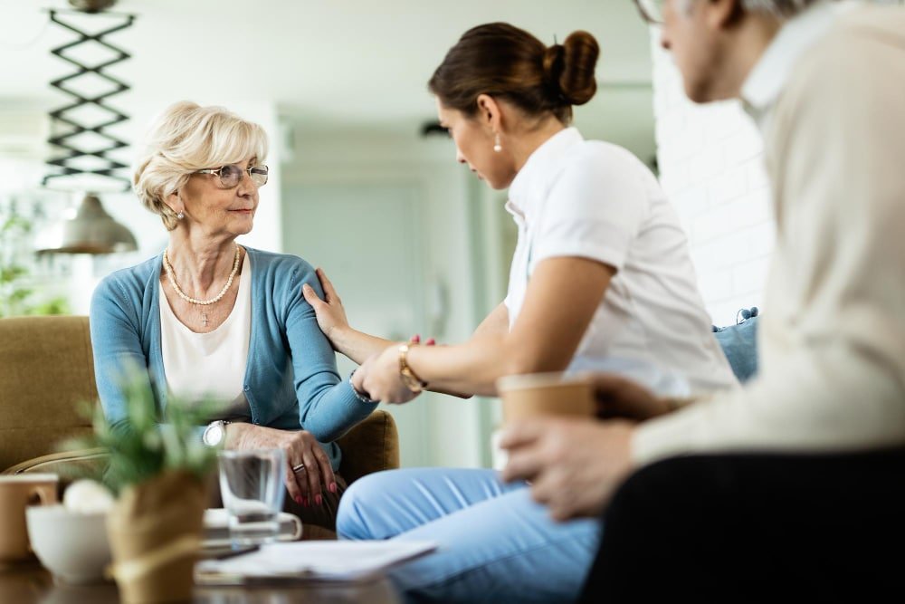 nurse communicates with senior woman during home visit