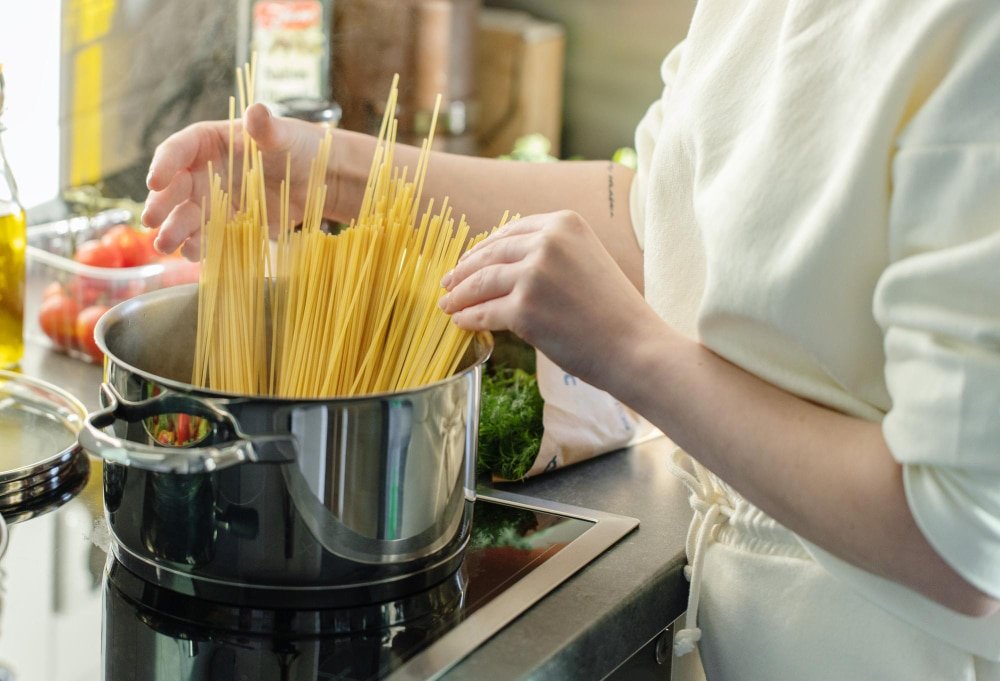 Hands of woman cooking pot of pasta