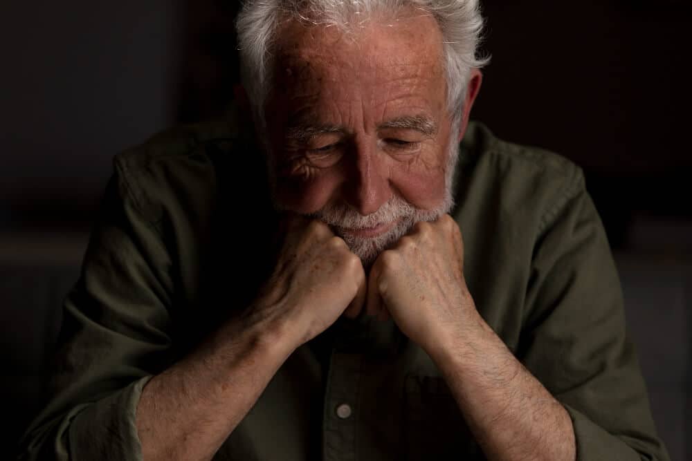 lonely senior man with his face in his hands