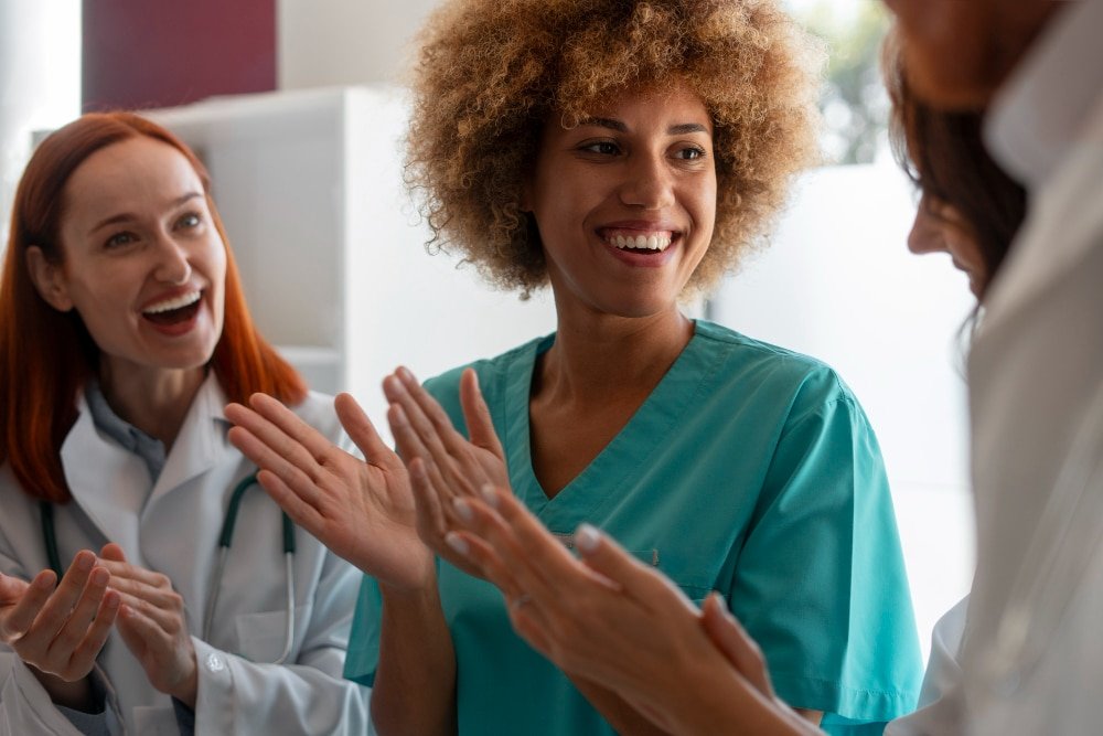 several smiling health care workers applaud