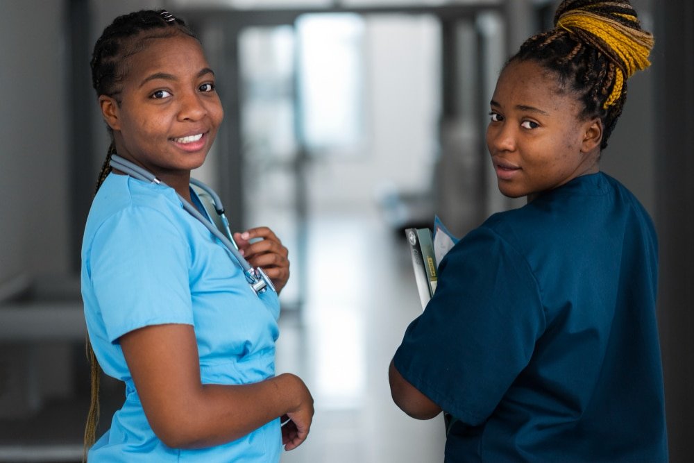 two young health care workers look back over their shoulders