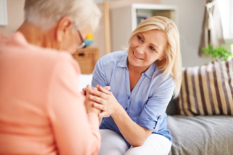 woman holds senior mom's hand