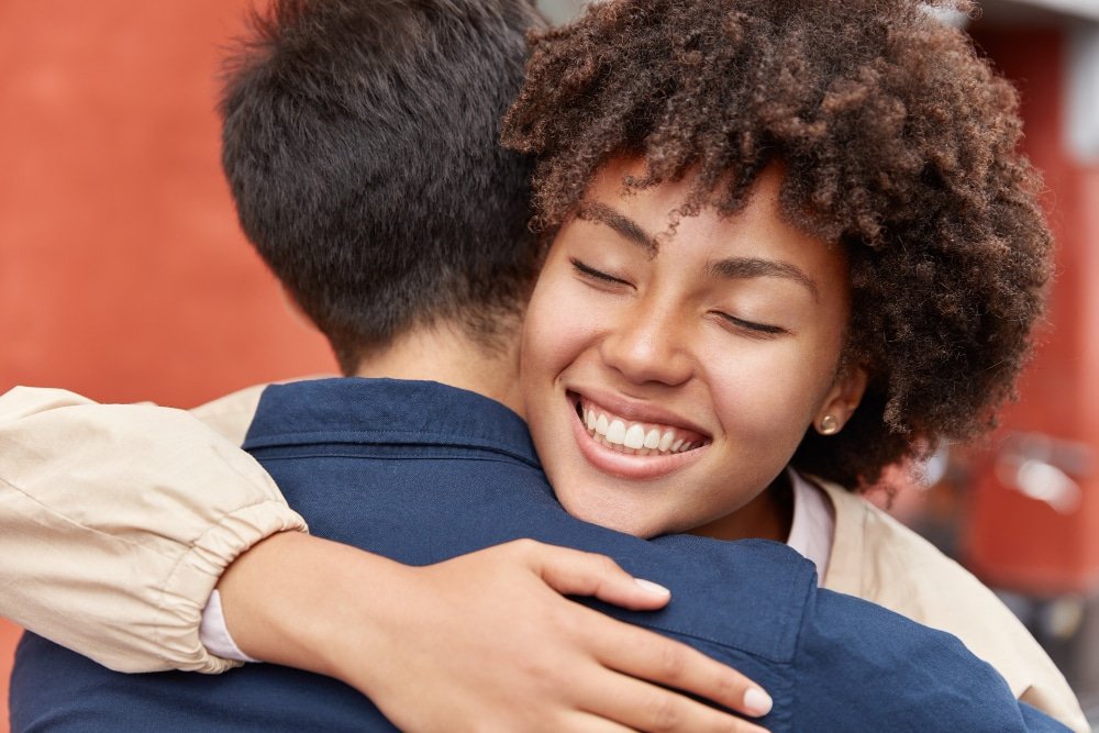 pretty young woman hugs a young man