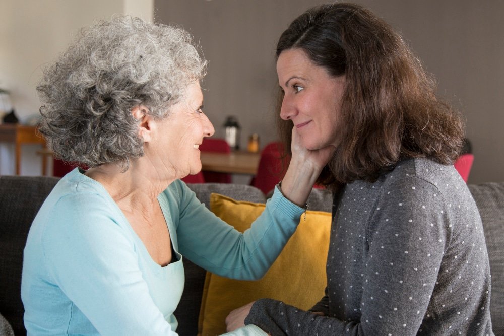 adult woman talks with elderly mother