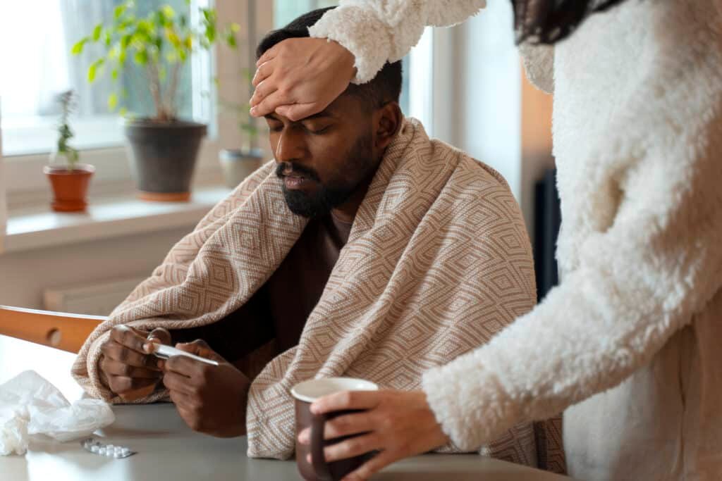 caregiver checks sick loved one's temperature