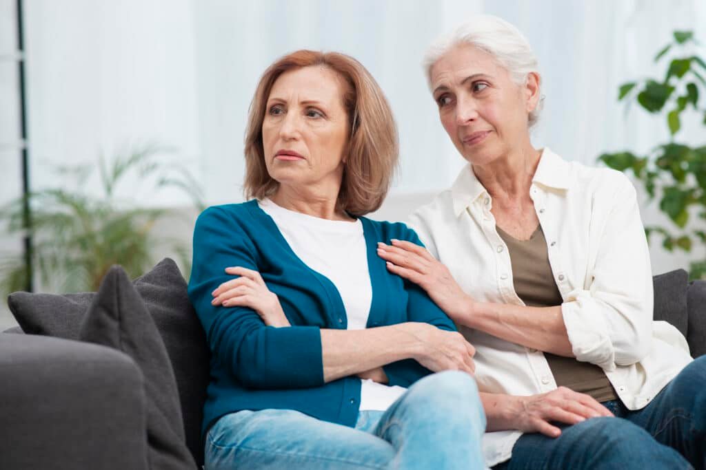 Mature woman resists a hug from her friend