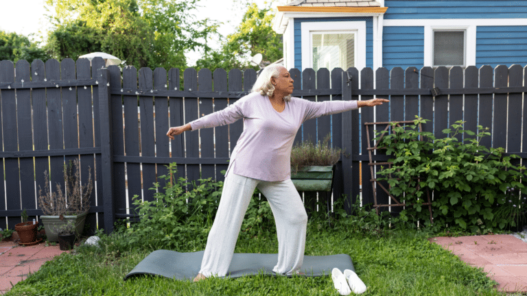 senior woman stretches while standing on yoga mat