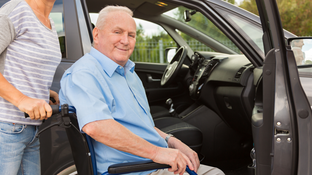 caregiver helps man into wheelchair