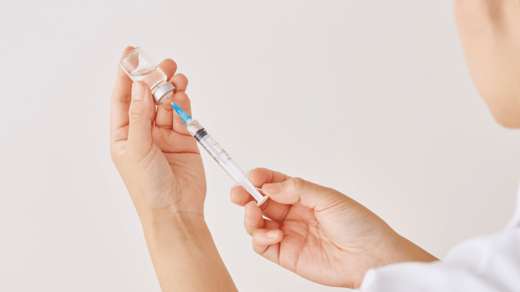 close of caregiver filling syringe for an injection