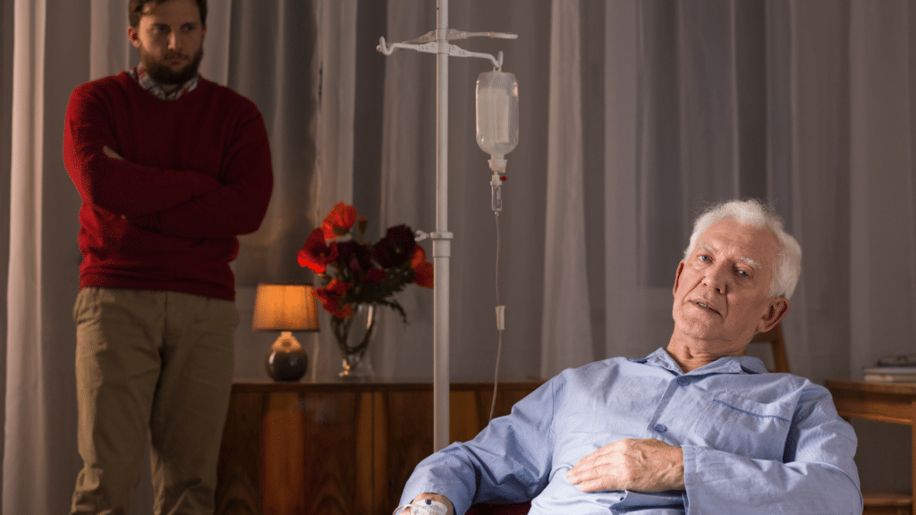 caregiver son watches as his elderly father receives dementia drug infusion