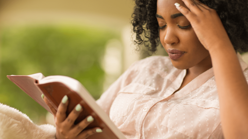 woman with a serious expression reads the Bible