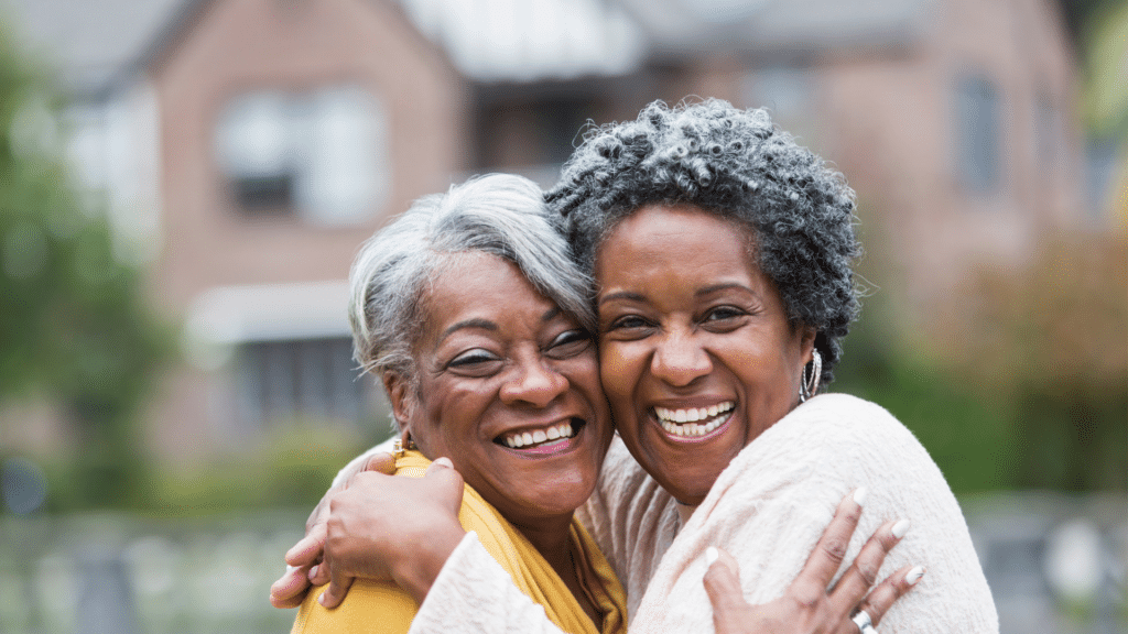 smiling senior women embrace one another