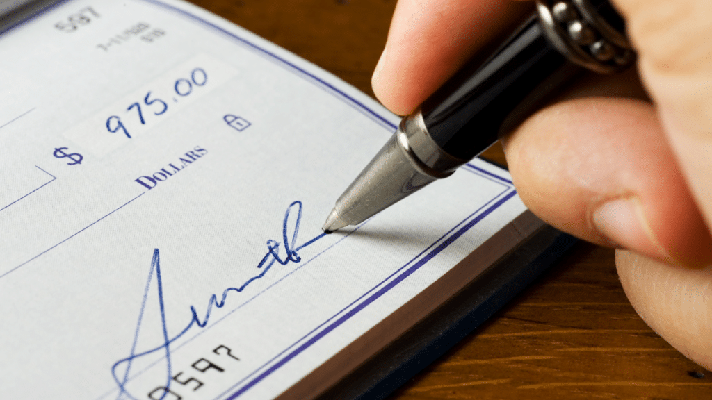 close-up of person signing a check